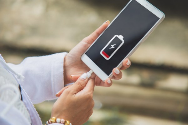 Close-up of a woman charging her cell phone with the charging icon